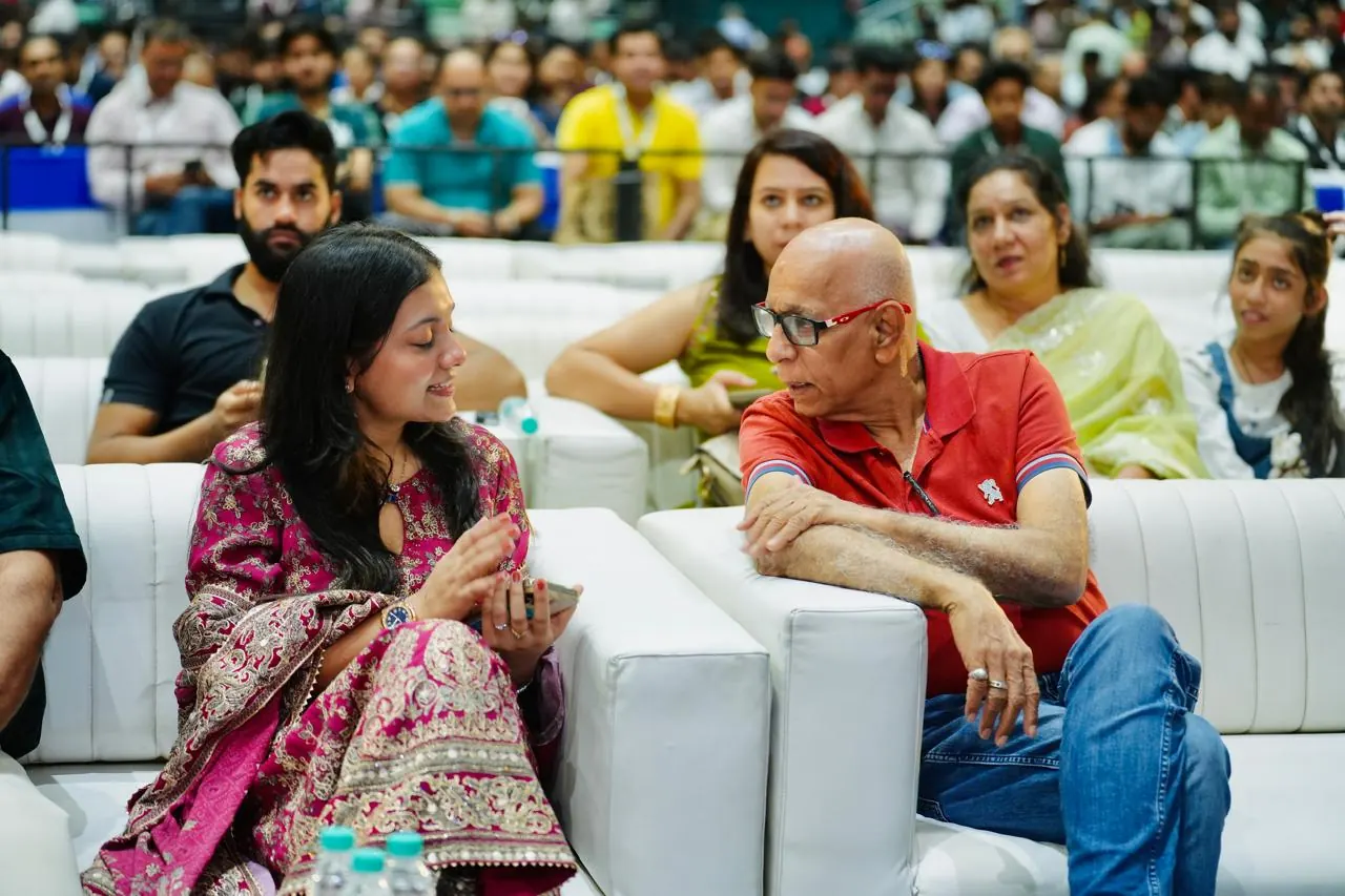 Two attendees in conversation in the front row during a session