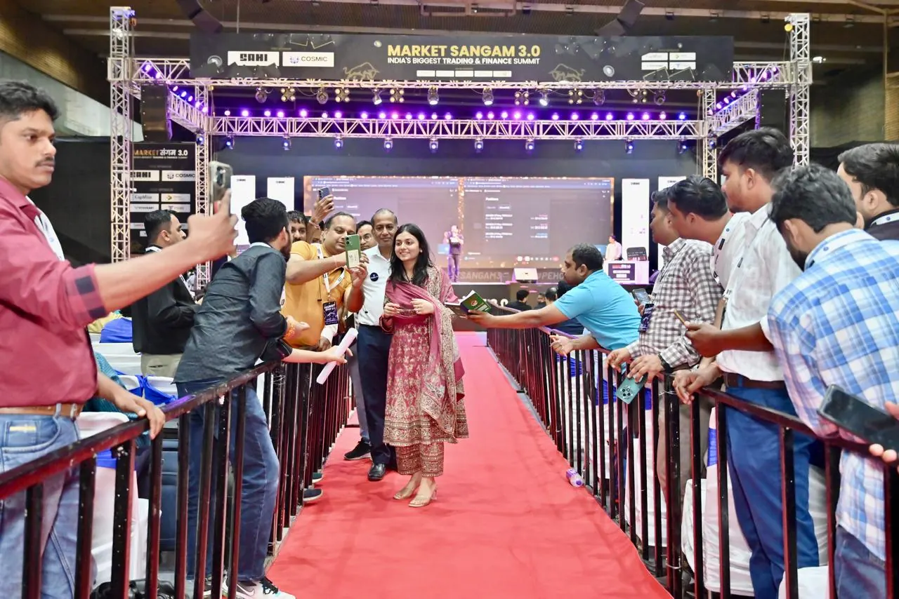 A speaker walks the aisle as attendees line the barriers
