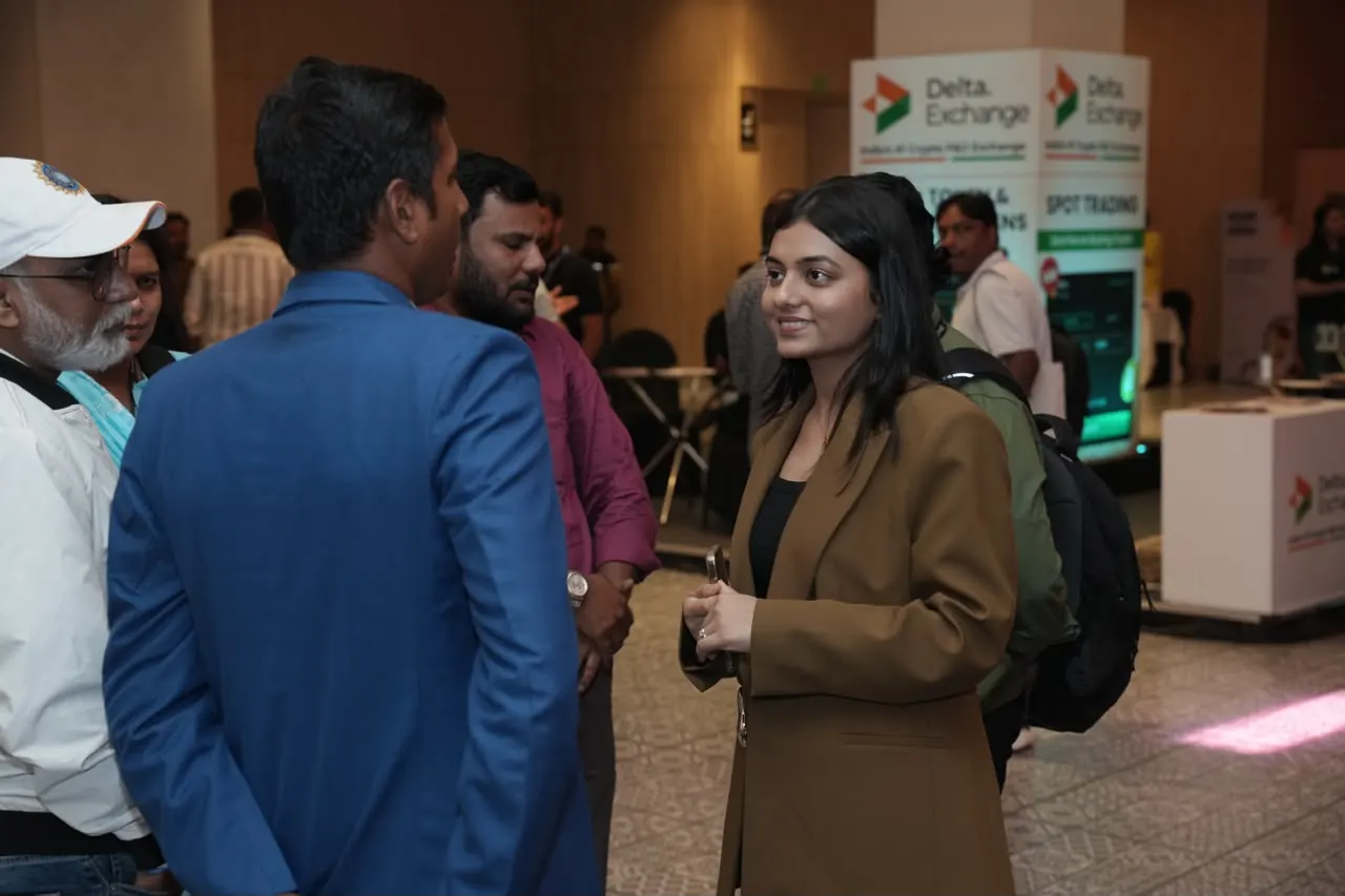 Attendees in conversation with the team at an exchange booth