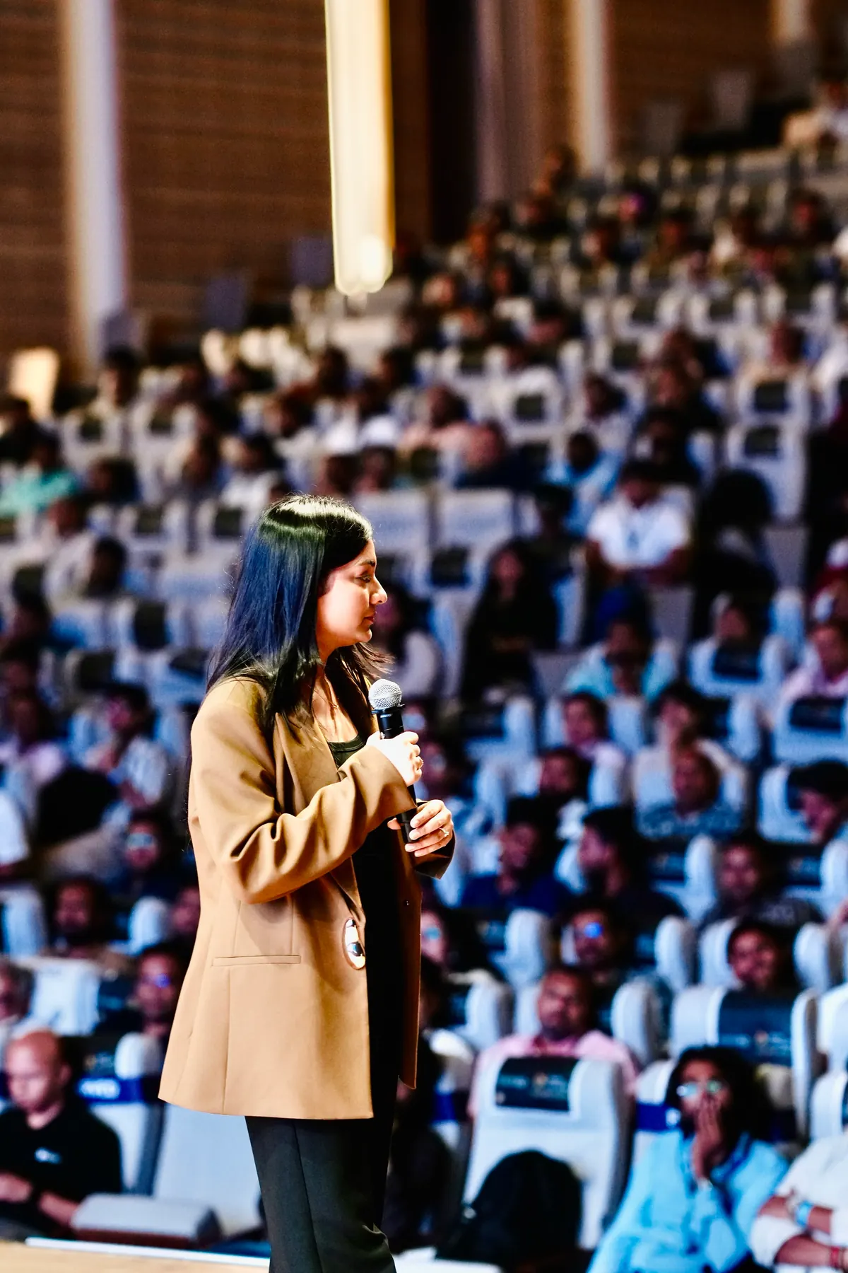A speaker presents to a seated auditorium audience